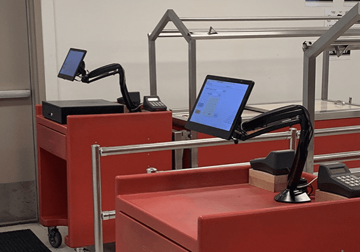 Two red checkout stations with touchscreen monitors